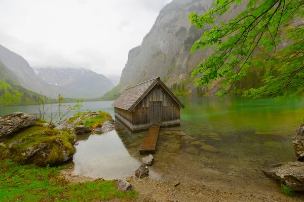 Yaz aylarında mavi gökyüzü ve bulutlar ile güzel bir güneşli bir günde doğal Obersee Gölü'nde geleneksel eski ahşap tekne evi Pastoral görünümü, Millipark Berchtesgadener Land, Bavyera, Almanya