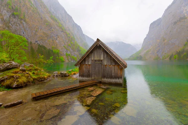 Yaz aylarında mavi gökyüzü ve bulutlar ile güzel bir güneşli bir günde doğal Obersee Gölü'nde geleneksel eski ahşap tekne evi Pastoral görünümü, Millipark Berchtesgadener Land, Bavyera, Almanya