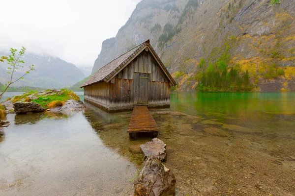 Yaz aylarında mavi gökyüzü ve bulutlar ile güzel bir güneşli bir günde doğal Obersee Gölü'nde geleneksel eski ahşap tekne evi Pastoral görünümü, Millipark Berchtesgadener Land, Bavyera, Almanya
