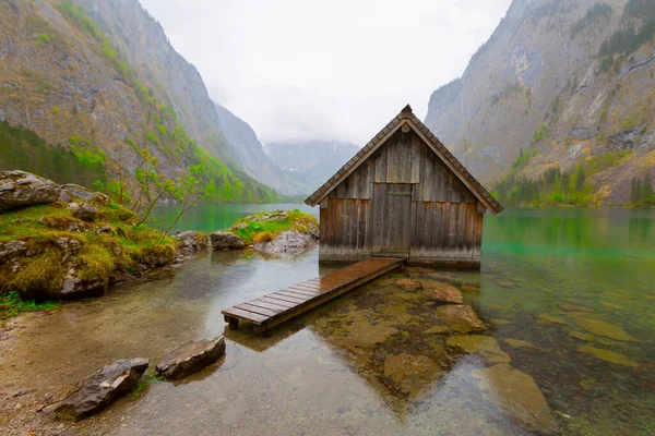 Yaz aylarında mavi gökyüzü ve bulutlar ile güzel bir güneşli bir günde doğal Obersee Gölü'nde geleneksel eski ahşap tekne evi Pastoral görünümü, Millipark Berchtesgadener Land, Bavyera, Almanya