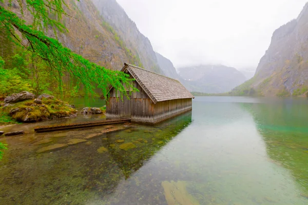 Yaz aylarında mavi gökyüzü ve bulutlar ile güzel bir güneşli bir günde doğal Obersee Gölü'nde geleneksel eski ahşap tekne evi Pastoral görünümü, Millipark Berchtesgadener Land, Bavyera, Almanya