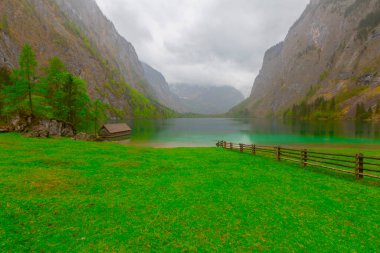 Yaz aylarında mavi gökyüzü ve bulutlar ile güzel bir güneşli bir günde doğal Obersee Gölü'nde geleneksel eski ahşap tekne evi Pastoral görünümü, Millipark Berchtesgadener Land, Bavyera, Almanya