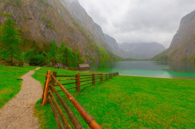 Yaz aylarında mavi gökyüzü ve bulutlar ile güzel bir güneşli bir günde doğal Obersee Gölü'nde geleneksel eski ahşap tekne evi Pastoral görünümü, Millipark Berchtesgadener Land, Bavyera, Almanya