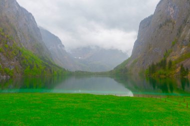 Yaz aylarında mavi gökyüzü ve bulutlar ile güzel bir güneşli bir günde doğal Obersee Gölü'nde geleneksel eski ahşap tekne evi Pastoral görünümü, Millipark Berchtesgadener Land, Bavyera, Almanya