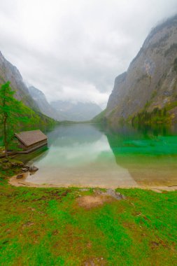Yaz aylarında mavi gökyüzü ve bulutlar ile güzel bir güneşli bir günde doğal Obersee Gölü'nde geleneksel eski ahşap tekne evi Pastoral görünümü, Millipark Berchtesgadener Land, Bavyera, Almanya