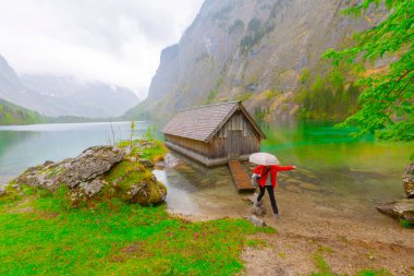 Yaz aylarında mavi gökyüzü ve bulutlar ile güzel bir güneşli bir günde doğal Obersee Gölü'nde geleneksel eski ahşap tekne evi Pastoral görünümü, Millipark Berchtesgadener Land, Bavyera, Almanya