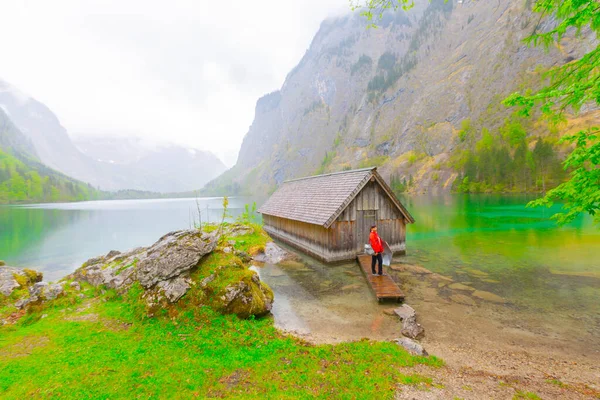 Yaz aylarında mavi gökyüzü ve bulutlar ile güzel bir güneşli bir günde doğal Obersee Gölü'nde geleneksel eski ahşap tekne evi Pastoral görünümü, Millipark Berchtesgadener Land, Bavyera, Almanya