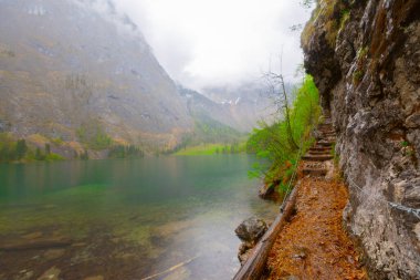 Yaz aylarında mavi gökyüzü ve bulutlar ile güzel bir güneşli bir günde doğal Obersee Gölü'nde geleneksel eski ahşap tekne evi Pastoral görünümü, Millipark Berchtesgadener Land, Bavyera, Almanya