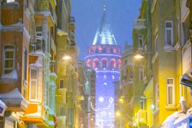  İstanbul 'da kış. Dar bir sokaktan tarihi Galata Kulesi manzarası ve karlı hava.
