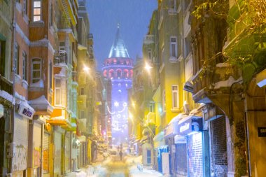  İstanbul 'da kış. Dar bir sokaktan tarihi Galata Kulesi manzarası ve karlı hava.
