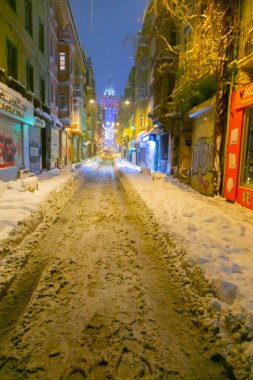  İstanbul 'da kış. Dar bir sokaktan tarihi Galata Kulesi manzarası ve karlı hava.