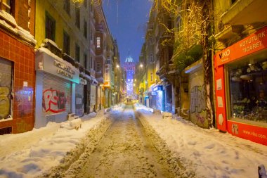 İstanbul 'da kış. Dar bir sokaktan tarihi Galata Kulesi manzarası ve karlı hava.
