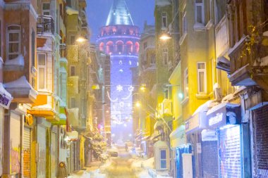  İstanbul 'da kış. Dar bir sokaktan tarihi Galata Kulesi manzarası ve karlı hava.