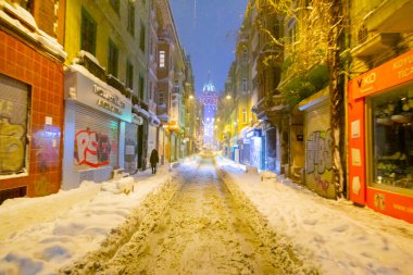  İstanbul 'da kış. Dar bir sokaktan tarihi Galata Kulesi manzarası ve karlı hava.