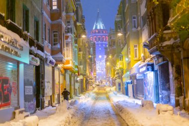  İstanbul 'da kış. Dar bir sokaktan tarihi Galata Kulesi manzarası ve karlı hava.