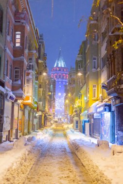  İstanbul 'da kış. Dar bir sokaktan tarihi Galata Kulesi manzarası ve karlı hava.