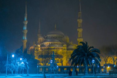 Mavi caminin ve çevresinin gece karlı manzarası