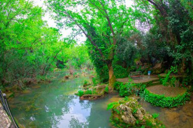 Türkiye 'nin Antalya kentindeki Kursunlu kentindeki sakin şelaleye üçlülerin arasından bakan bir fotoğraf.