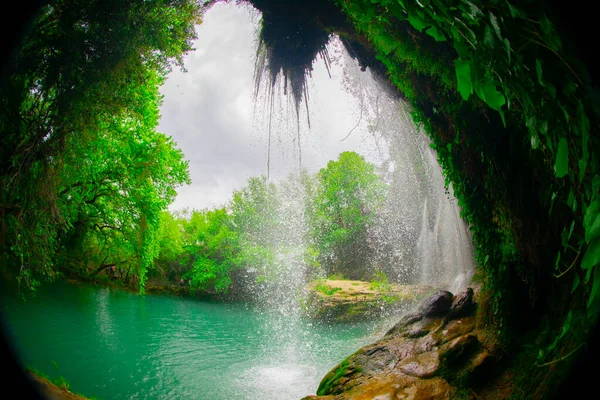 A photo looking through the threes to the tranquil waterfall at Kursunlu in Antalya, Turkey.