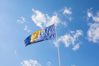 Bosna-Hersek 'in büyük bayrağı güneşli bir günde gökyüzüne doğru dalgalanan bayrak direğinde.