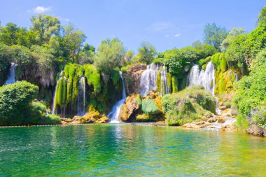 Güney Bosna-Hersek 'te Kravica şelalelerinin altında kürek çeken küçük bir tekne.