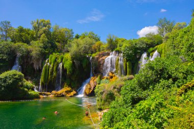 Güney Bosna-Hersek 'te Kravica şelalelerinin altında kürek çeken küçük bir tekne.