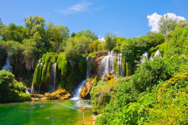 Güney Bosna-Hersek 'te Kravica şelalelerinin altında kürek çeken küçük bir tekne.