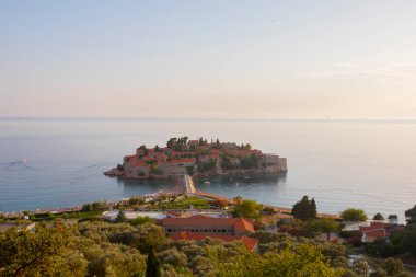 Karadağ 'daki küçük adacık ve tatil beldesi Sveti Stefan' ın üzerindeki güzel günbatımı manzarası. Balkanlar, Adriyatik denizi, Avrupa.