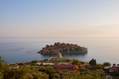 Karadağ 'daki küçük adacık ve tatil beldesi Sveti Stefan' ın üzerindeki güzel günbatımı manzarası. Balkanlar, Adriyatik denizi, Avrupa.