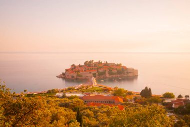 Karadağ 'daki küçük adacık ve tatil beldesi Sveti Stefan' ın üzerindeki güzel günbatımı manzarası. Balkanlar, Adriyatik denizi, Avrupa.