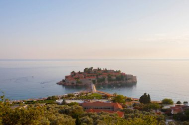 Karadağ 'daki küçük adacık ve tatil beldesi Sveti Stefan' ın üzerindeki güzel günbatımı manzarası. Balkanlar, Adriyatik denizi, Avrupa.