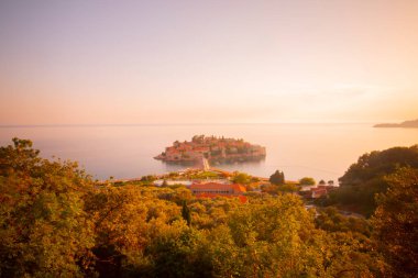 Karadağ 'daki küçük adacık ve tatil beldesi Sveti Stefan' ın üzerindeki güzel günbatımı manzarası. Balkanlar, Adriyatik denizi, Avrupa.
