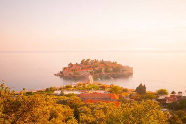 Karadağ 'daki küçük adacık ve tatil beldesi Sveti Stefan' ın üzerindeki güzel günbatımı manzarası. Balkanlar, Adriyatik denizi, Avrupa.