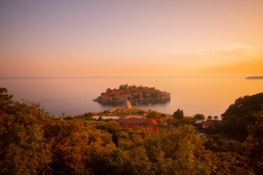 Karadağ 'daki küçük adacık ve tatil beldesi Sveti Stefan' ın üzerindeki güzel günbatımı manzarası. Balkanlar, Adriyatik denizi, Avrupa.