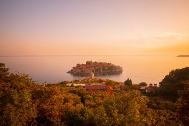 Karadağ 'daki küçük adacık ve tatil beldesi Sveti Stefan' ın üzerindeki güzel günbatımı manzarası. Balkanlar, Adriyatik denizi, Avrupa.