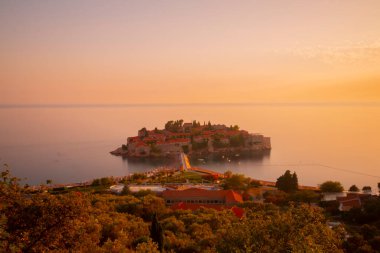 Karadağ 'daki küçük adacık ve tatil beldesi Sveti Stefan' ın üzerindeki güzel günbatımı manzarası. Balkanlar, Adriyatik denizi, Avrupa.