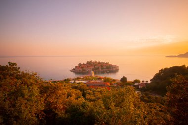 Karadağ 'daki küçük adacık ve tatil beldesi Sveti Stefan' ın üzerindeki güzel günbatımı manzarası. Balkanlar, Adriyatik denizi, Avrupa.