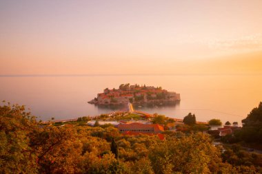 Karadağ 'daki küçük adacık ve tatil beldesi Sveti Stefan' ın üzerindeki güzel günbatımı manzarası. Balkanlar, Adriyatik denizi, Avrupa.