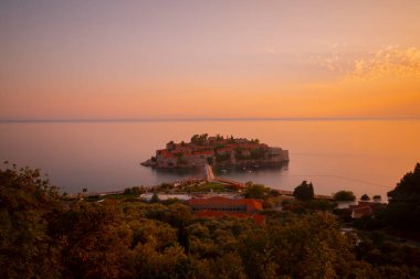 Karadağ 'daki küçük adacık ve tatil beldesi Sveti Stefan' ın üzerindeki güzel günbatımı manzarası. Balkanlar, Adriyatik denizi, Avrupa.