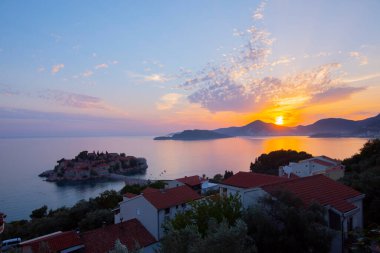 Karadağ 'daki küçük adacık ve tatil beldesi Sveti Stefan' ın üzerindeki güzel günbatımı manzarası. Balkanlar, Adriyatik denizi, Avrupa.