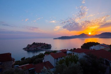 Karadağ 'daki küçük adacık ve tatil beldesi Sveti Stefan' ın üzerindeki güzel günbatımı manzarası. Balkanlar, Adriyatik denizi, Avrupa.