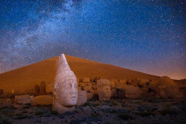 East terrace of Mount Nemrut at sunrise with Great alter in front of statues and the tumulus. The UNESCO World Heritage Site at Mount Nemrut where King Antiochus of Commagene is reputedly entombed.