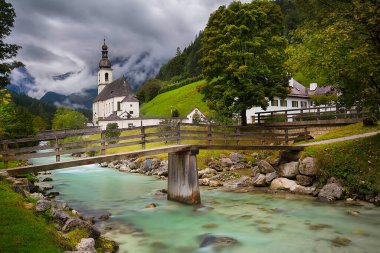 Ramsau bei Berchtesgaden, Almanya. Bavyera 'daki Berchtesgadener Toprakları' ndaki Ramsau Ulusal Parkı 'nın sonbahar manzarası. St. Sebastian Kilisesi ve Ramsauer Nehri' nin inanılmaz sezonluk manzarası..
