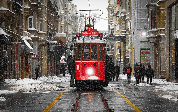 Old tram moves along Isteklal Street through a crowd of people towards Taksim Square. Symbol of Istanbul