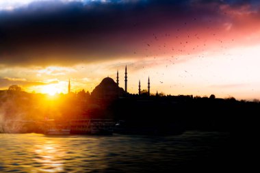 Günbatımı İstanbul, Türkiye 'de Süleyman Camii (Osmanlı İmparatorluğu Camii) ile birlikte. İstanbul 'daki Galata Köprüsü' nden görüntü.