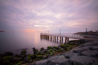 Uzun pozlama görüntü dramatik günbatımı veya gündoğumu, gökyüzü ve bulutlar üzerinde tropikal deniz manzara manzara içinde denize içinde eski küçük İskelesi