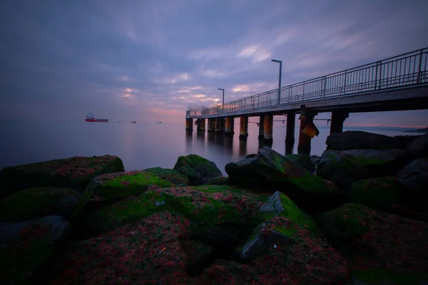 ドラマチックな日没や日の出 空と熱帯の海景色を風景雲の長い露出画像で海の古い小さな桟橋 — ストック写真