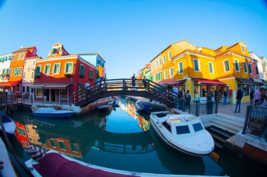 Burano adasının renkli evleri. İtalya 'nın Venedik Bölgesi' nde, Venedik Eyaleti 'nde balıkçı tekneleri ve taş köprüsü olan dar su kanalının fondamenta dolgusu üzerinde çok renkli binalar. Burano kartpostalı