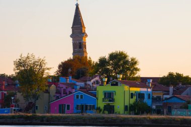 Burano adasının renkli evleri. İtalya 'nın Venedik Bölgesi' nde, Venedik Eyaleti 'nde balıkçı tekneleri ve taş köprüsü olan dar su kanalının fondamenta dolgusu üzerinde çok renkli binalar. Burano kartpostalı