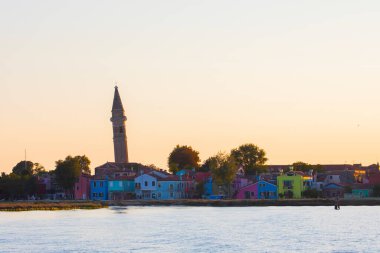 Burano adasının renkli evleri. İtalya 'nın Venedik Bölgesi' nde, Venedik Eyaleti 'nde balıkçı tekneleri ve taş köprüsü olan dar su kanalının fondamenta dolgusu üzerinde çok renkli binalar. Burano kartpostalı